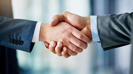 Closeup shot of two businessmen shaking hands in an office